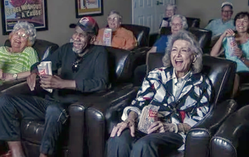 A group of people are sitting in a movie theater, watching a movie. AI generated content