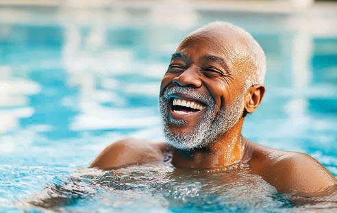 A man with a beard and mustache is smiling while floating in a pool. AI generated content